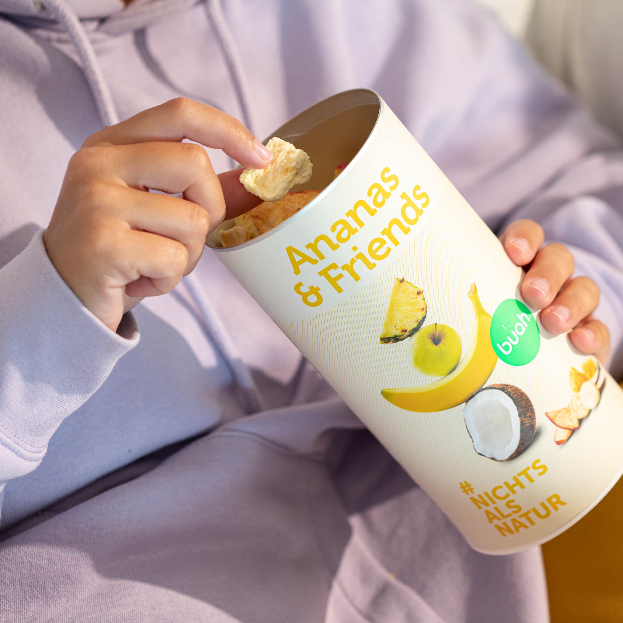 Volle, gelbe Dose Ananas & Friends wird von einer Person gehalten