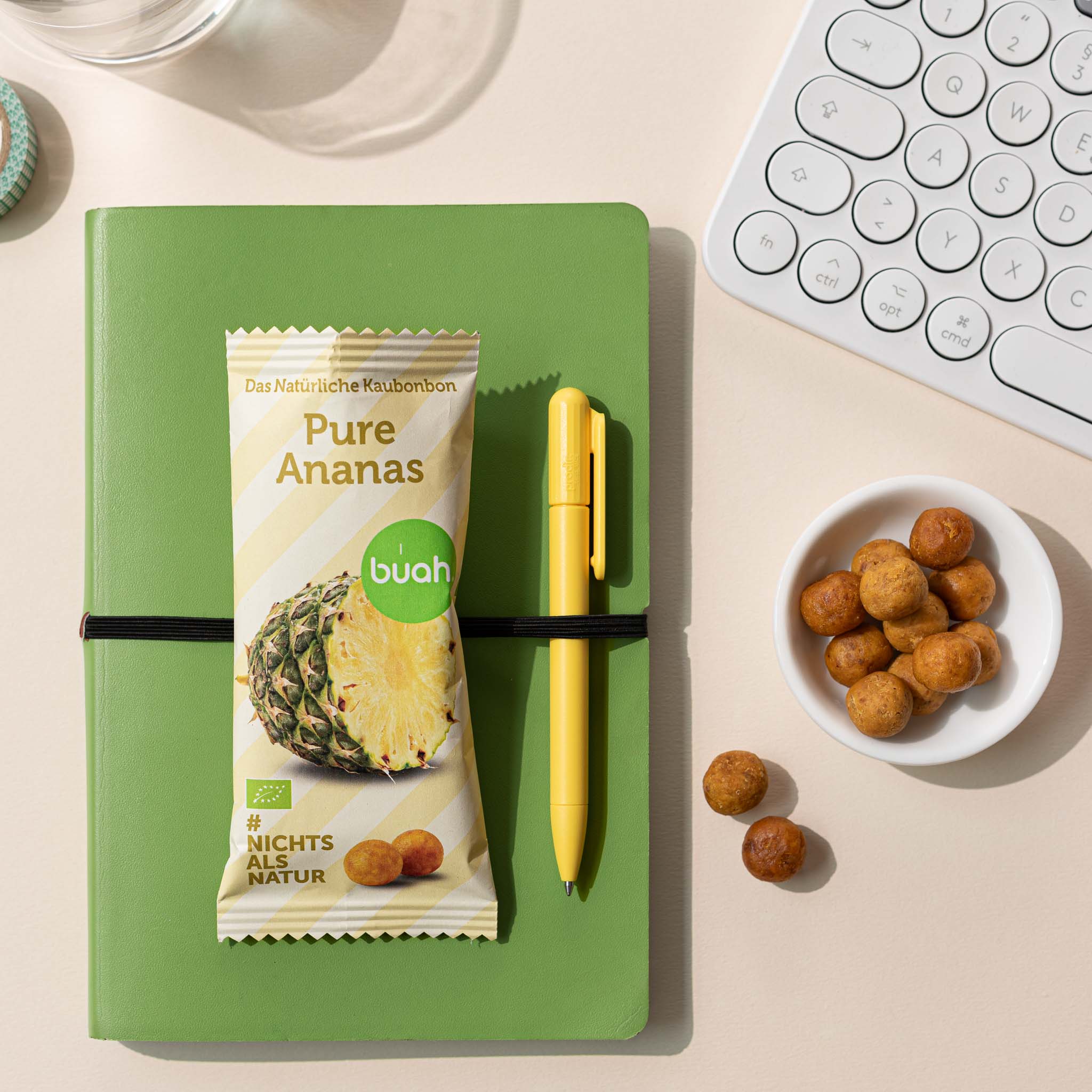 buah Ananas Kaubonbon Packung liegt auf gruenem Notizbuch mit frischen Kaubonbon daneben