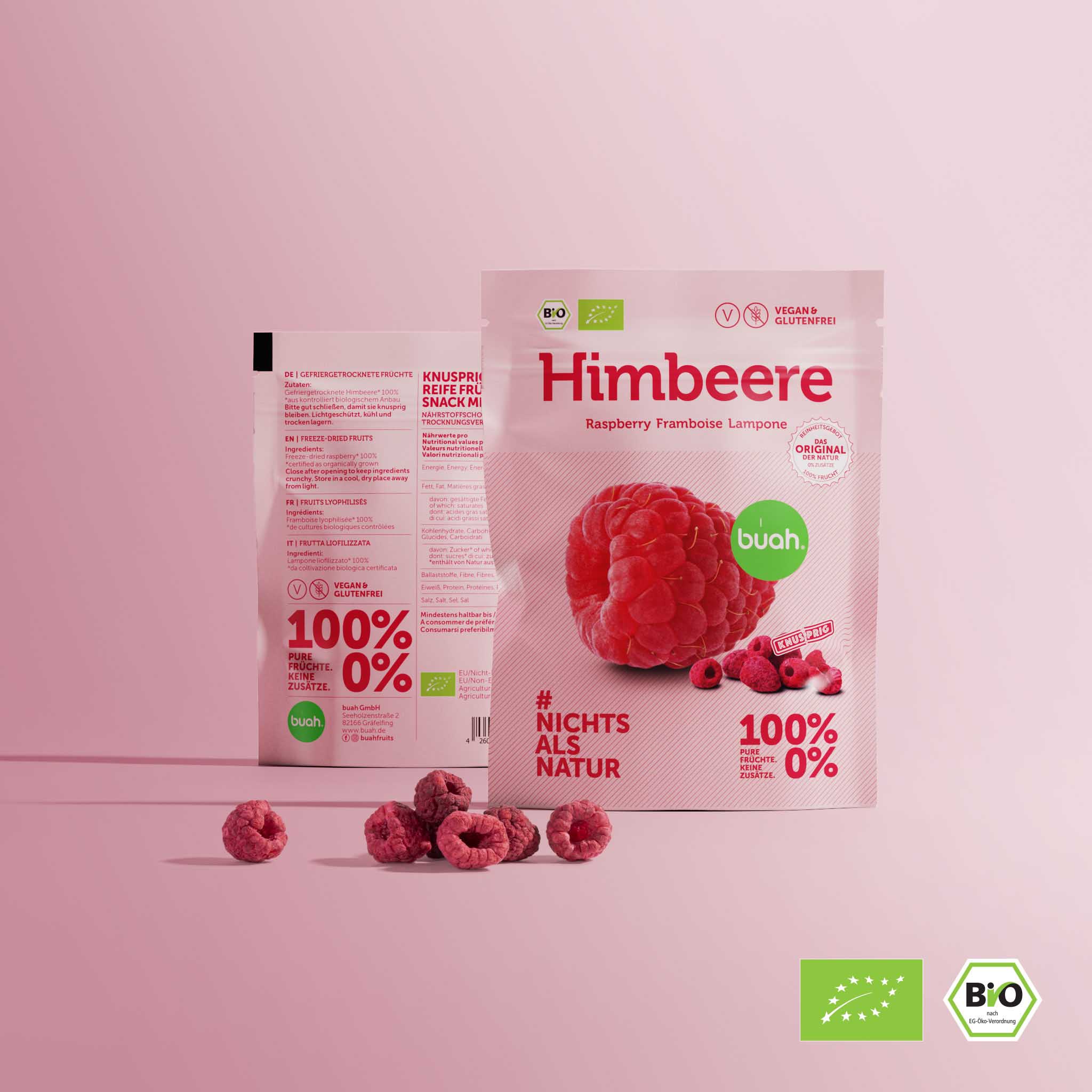 Deux packs de collations buah se trouvent l'un à cÎté de l'autre avec des framboises lyophilisées sur fond rose