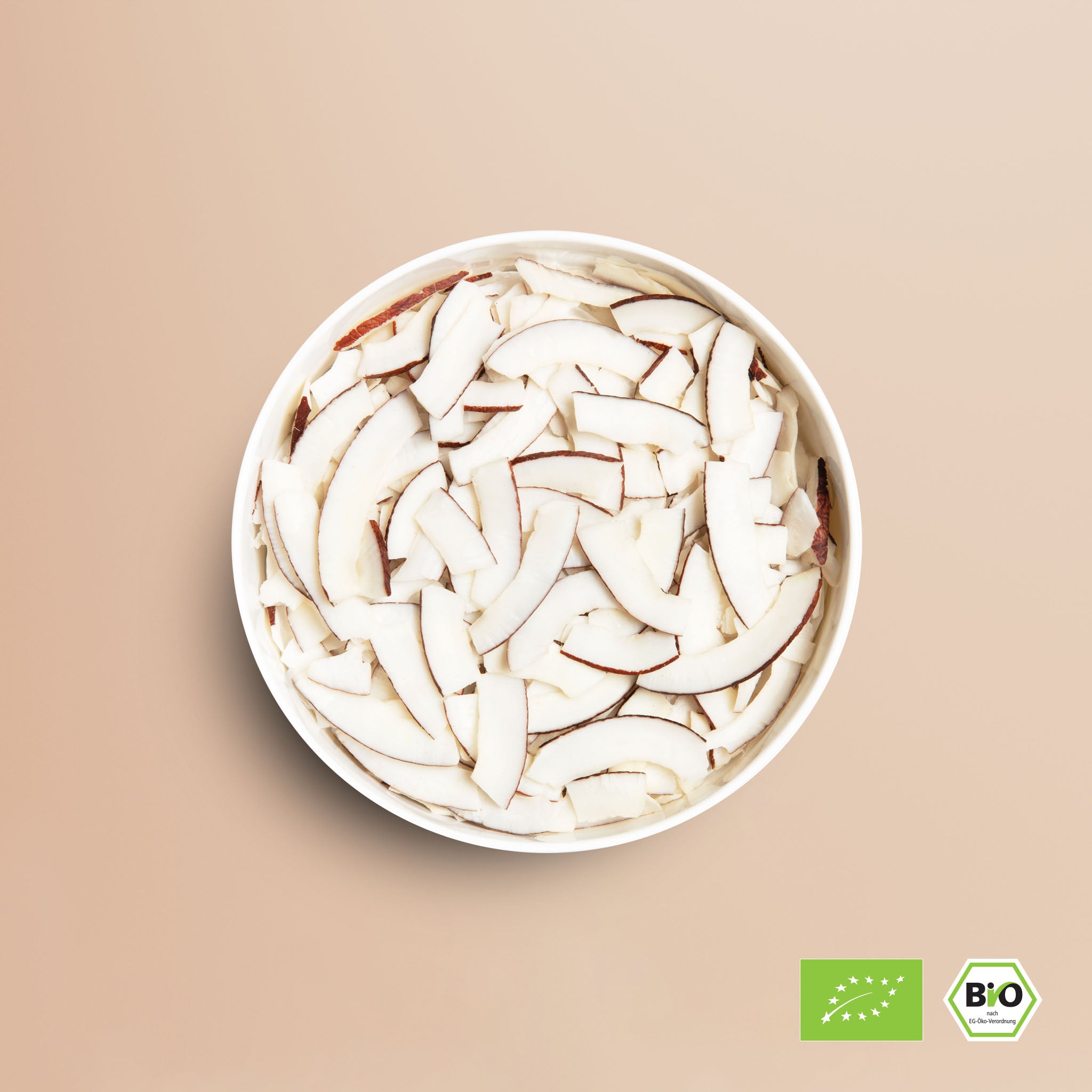 buah Kokoschips in einer weissen Schale vor braunem Hintergrund