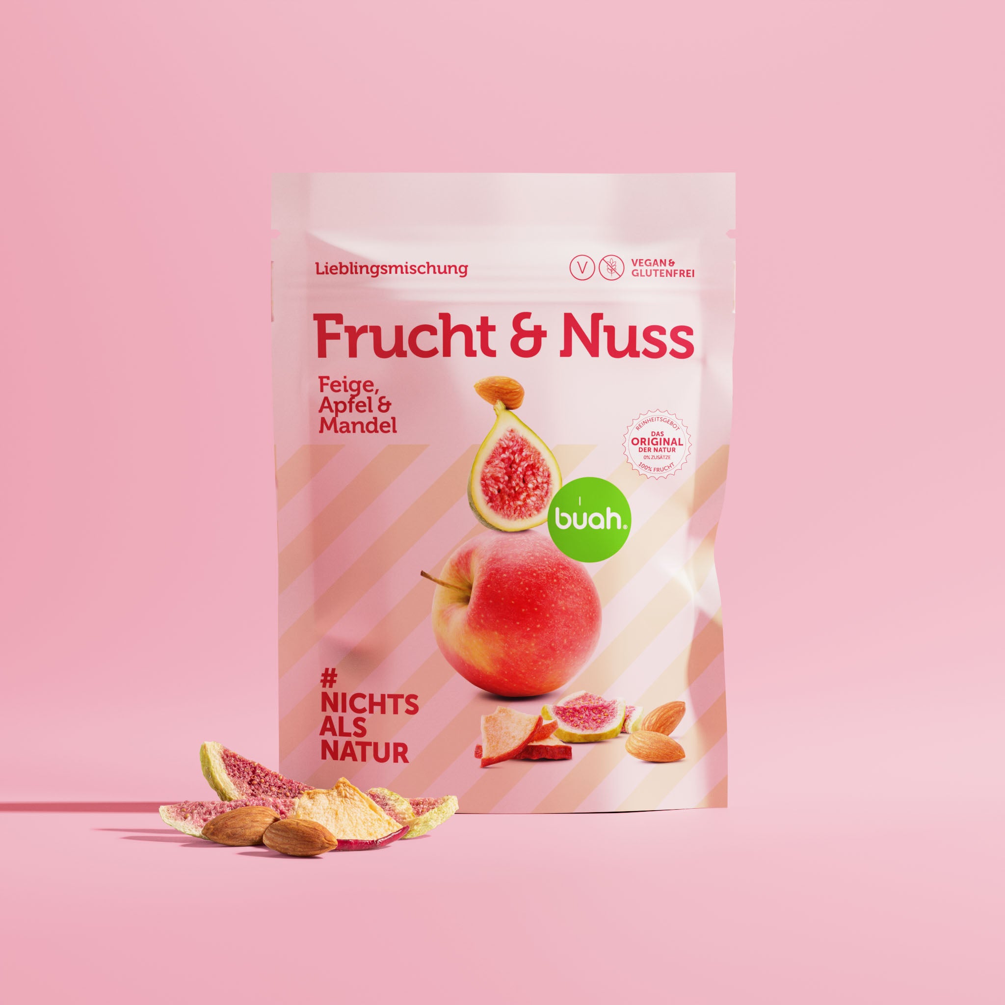 Packung buah Frucht & Nuss Mischung der Sorte Feige, Apfel und Mandel vor rosa Hintergrund