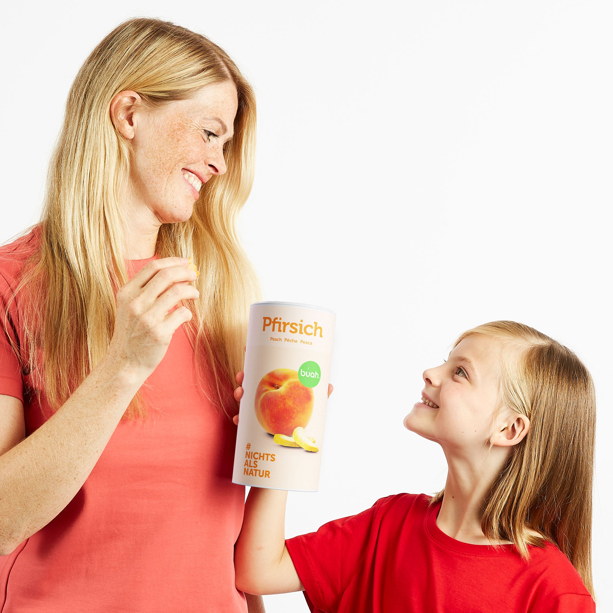 Maman et sa fille se regardent et tiennent une boîte de pêche lyophilisée Buah