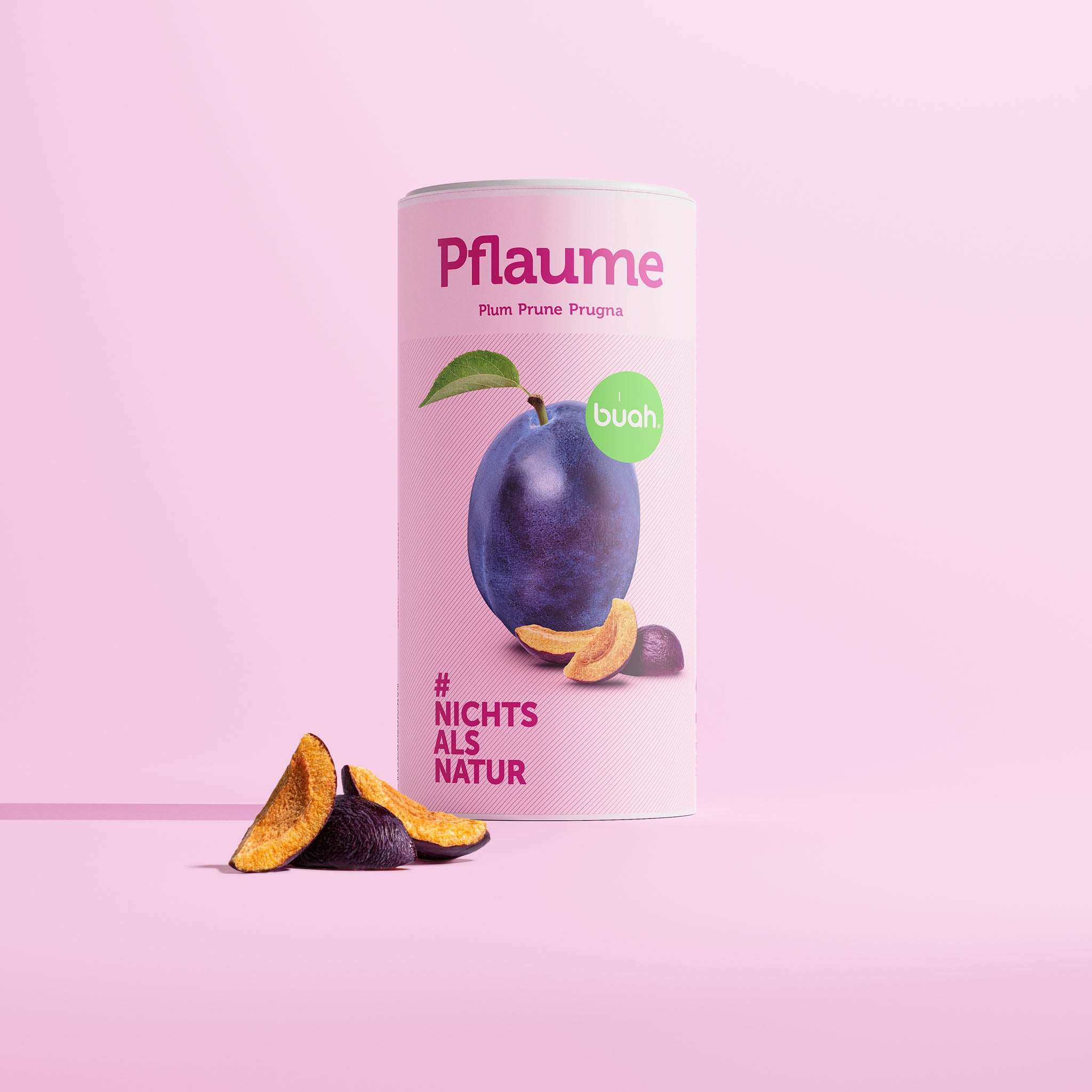 Grande boîte de prune lyophilisée Buah avec une prune fraîche en forme de cylindre, un emballage rose et une écriture violette.