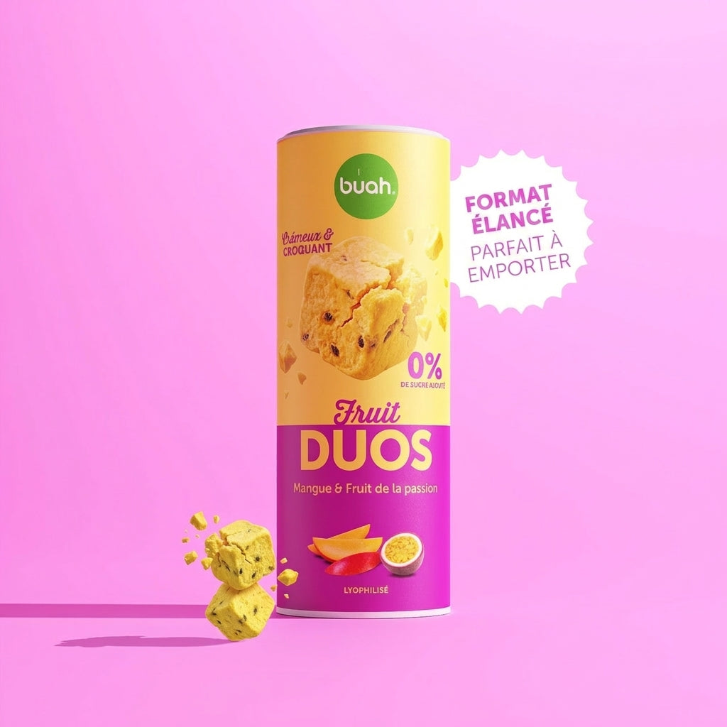 Une boîte Slim de buah Fruit DUOS Mangue & Fruit de la passion se trouve au centre devant un fond rose. À côté se trouve une bulle blanche en forme d'étoile avec le texte « BOÎTE SLIM PARFAITE À EMPORTER ». Des cubes de fruits flottent à gauche.