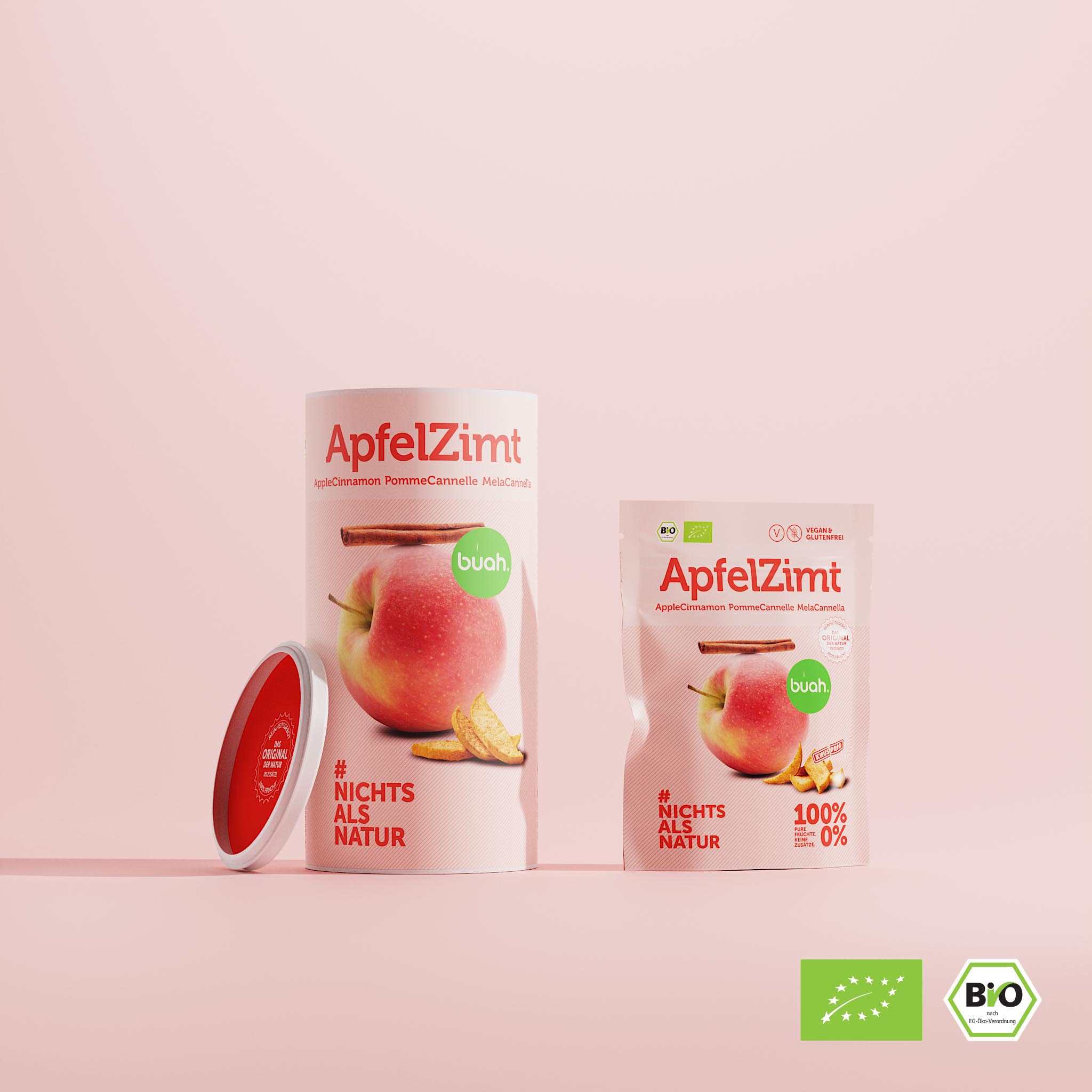 buah ApfelZimt Dose und kleineres Snackpack stehen nebeneinander vor rosa Hintergrund 