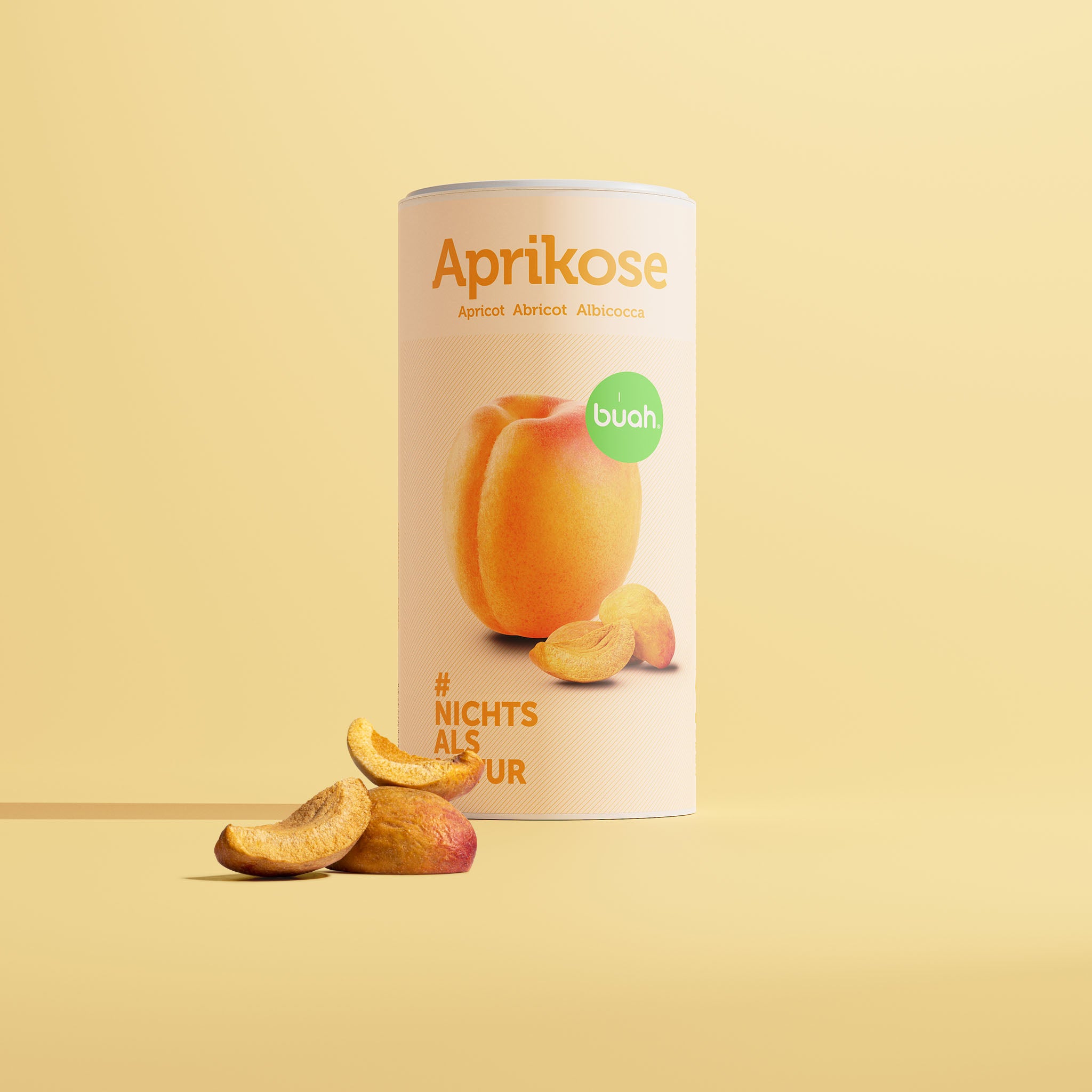 buah abricot lyophilisé dans une grande boîte avec des sculptures d'abricot devant la boîte et un fond jaune 