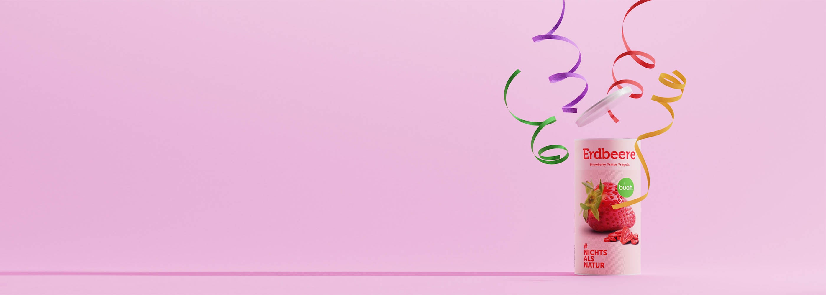 buah birthday grosse Dose Erdbeere vor lila Hintergrund mit Luftschlangen um die Dose 