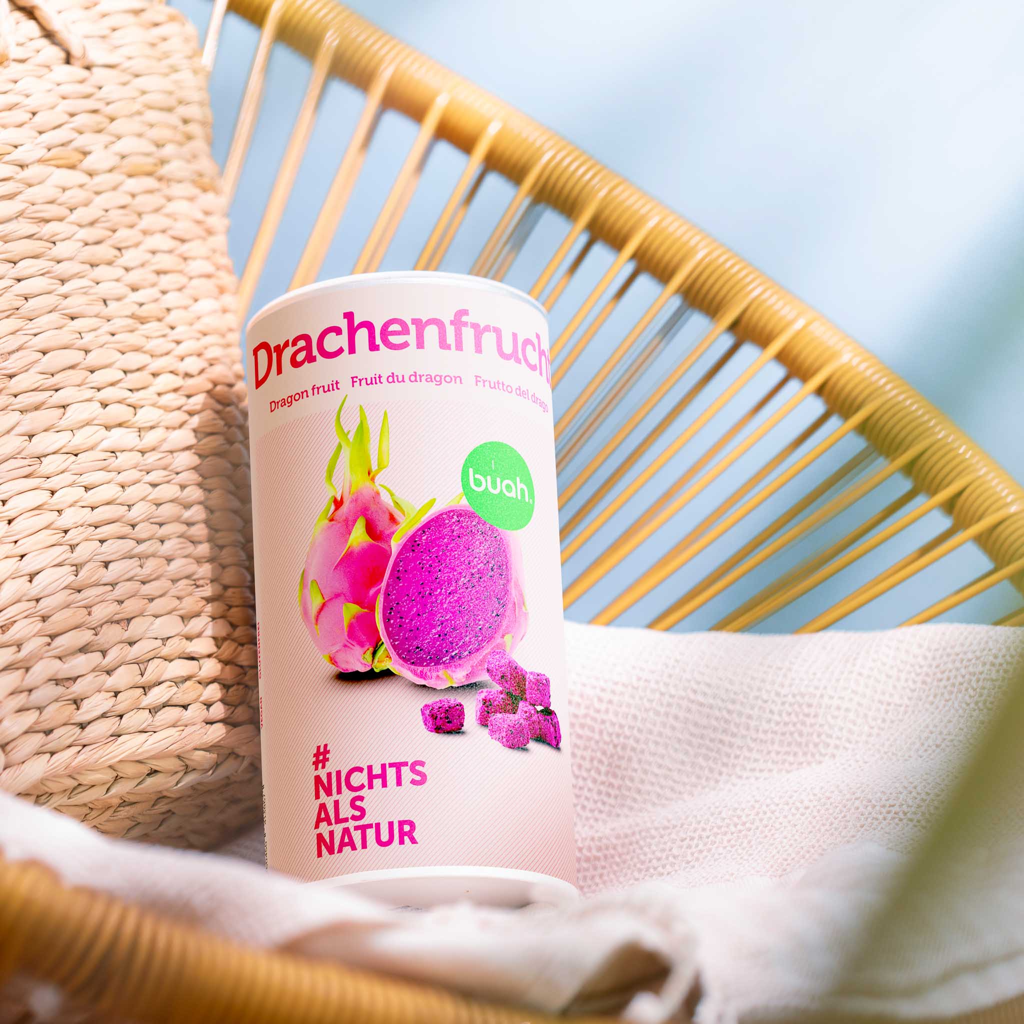 buah Dose gefriergetrocknete Drachenfrucht neben einer Starndtasche  auf einer Sonnenliege
