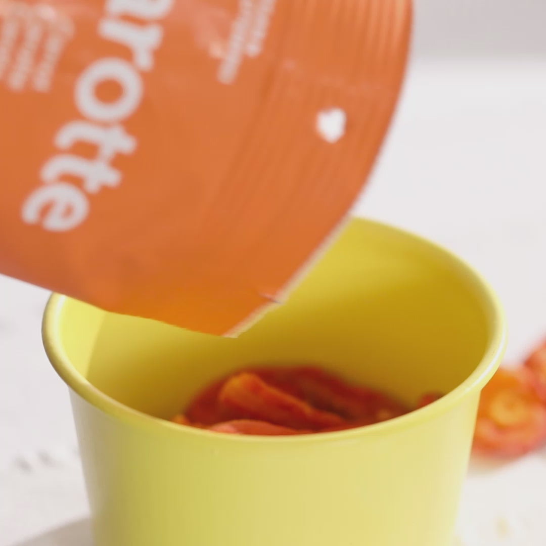 Video, wie Karottenchips von buah aus der Packung in eine Schale gegeben werden