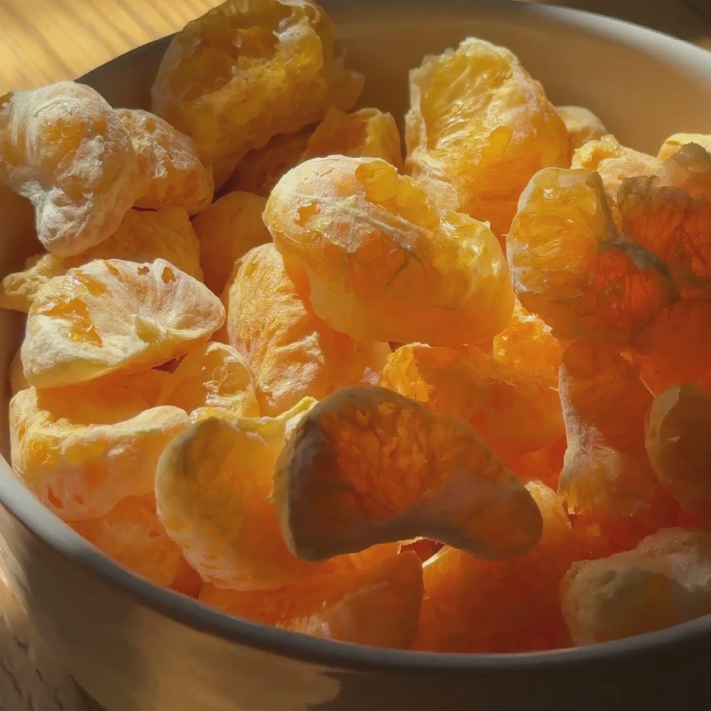Video der buah gefriergetrockneten Mandarine, die in einer Schale von der Sonne angestrahlt wird